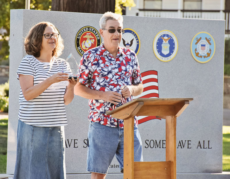 Greg Little, who co-owns the Mariposa Gazette with his wife, Nicole (also shown), presents recognition plaques during the July 4, 2020 dedication of the new Mariposa County Veterans Memorial.